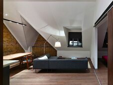 Renovierte beleuchtete Dachgeschosswohnung mit Ziegelwand und Designermöbeln
