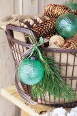 Pine cones and green baubles in metal basket