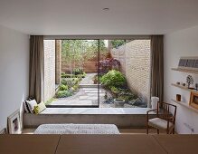 View from bedroom past concrete bench into courtyard