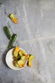 Courgette and courgette flowers on a grey stone surface