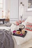 Frühstückstablett mit Kaffee und Gebäck auf Doppelbett