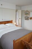 Traditionelles Schlafzimmer mit Holzbett, grauer Tagesdecke und abgetönter Wandfarbe mit Wandleiste