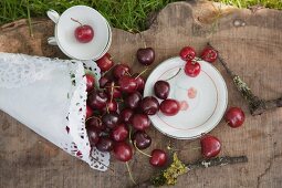 Crockery printed with cherry pattern and paper cone of cherries