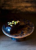 A slice of vegan chocolate cake with pistachio nuts