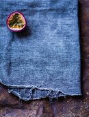 Half a passion fruit on a blue cloth