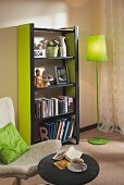 Black and green DIY shelving made from wooden slats and MDF panels in loving room
