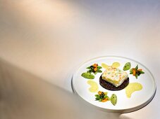A dish by Dieter Müller: souffléd branzini with curry sauce, black rice and green asparagus