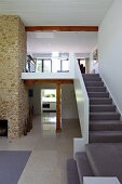 Staircase with light grey carpet leading to gallery in open-plan luxury interior