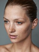 A close-up portrait of a young woman with lots of freckles