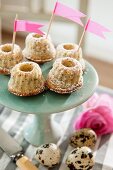 Miniature Bundt cakes with pink flags on green cake stand