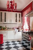 Chequered floor, red-and-white gingham curtains and contemporary chandelier in white kitchen