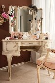 Jewellery, perfume bottles and cosmetics on dressing table in ornate Rococo style