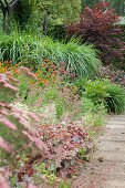 Flowering herbaceous border and stone-flagged garden path