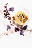 A praline with gold leaf and candied violets