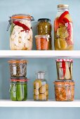 Various jars of preserved vegetables on a shelf