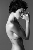 Junge Frau oben ohne, Tattoo unter der Brust (s/w-Foto)