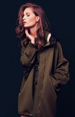 Junge Frau mit Oversize-Jacke in Olivgrün