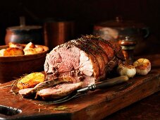 A carved boneless leg of lamb on a chopping board