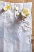 Zitronen-Aioli im Gläschen auf weißem Papier (Aufsicht)