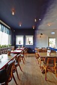 Wooden table and leather chairs in restaurant with blue wall
