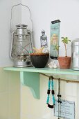 Vintage-style ornaments and storm lamp on mint-green bracket shelf