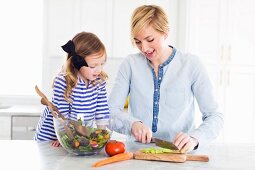 Mutter & Tochter beim Zubereiten von Salat in der Küche