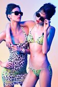Zwei junge Frauen in buntem Bikini und Strandkleid
