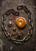A face made from a bagel, an iron chain and a padlock