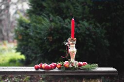 Rote Äpfel und Tannenzweig um Silber Kerzenständer mit roter Kerze