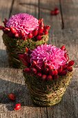 Wicker baskets with rose hips, moss and chrysanthemums as table decoration
