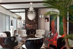 Sessel mit weißem Lederbezug und schwarze Kunststoff-Sitzschale unter Klassiker Pendelleuchte in offenem Wohnraum in Retrostil