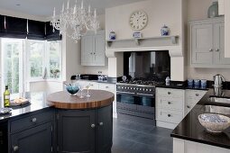 Free-standing kitchen counter with integrated, round, walnut butchers' block in country-house kitchen
