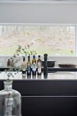 Vinegar and oil bottles on kitchen counter in front of window with a view