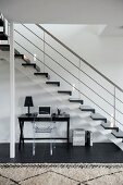 Desk and Ghost chair below staircase in contemporary stairwell