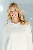 Junge blonde Frau in naturfarbenem Wollpullover