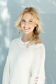 Junge blonde Frau in naturfarbenem Wollpullover