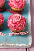 Vanilla cupcakes with pink mascarpone cream and decorative flowers