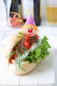 A salmon roll with egg, lettuce and dill, decorated with a clown face