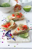 Baguette slices topped with salmon, mayonnaise, lime, and dill
