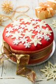 Christmas cake decorated with sugar snow flakes and a gold ribbon