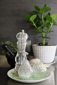 Salt cellar and pepper mill on plate in front of grey wall