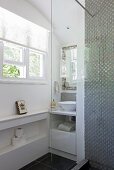 Blick von Duschbereich auf Waschtisch in Nische mit Fenster