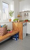 White fitted kitchen with integrated bench made from oiled oak