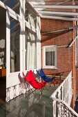 Butterfly easy chairs on terrace with glass roof