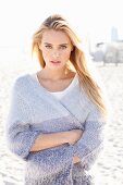 Young blonde woman wearing lilac cardigan on beach