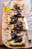 Puff pastry pizza with goat's cheese, caramelised balsamic onions and almonds