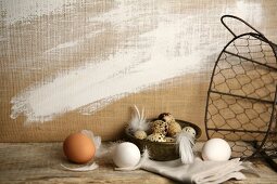 Hens' eggs, quail's eggs, feathers and wire basket