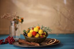 Various winter fruits in a metal bowl