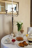 Runder Frühstückstisch mit Silber-Kerzenständer und Tulpenstrauss