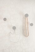Hand-made concrete wall hooks, one with string of wooden beads